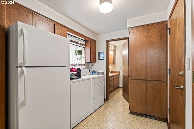 8050 SW 103rd Ave, Beaverton, OR 97008 - kitchen featuring freestanding refrigerator, washing machine and clothes dryer, light countertops, brown cabinetry, and light floors