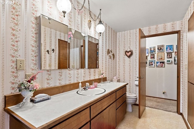 8050 SW 103rd Ave, Beaverton, OR 97008 - bathroom featuring vanity, toilet, wallpapered walls, and baseboards