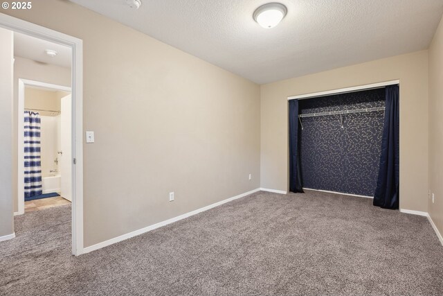 carpeted empty room featuring a textured ceiling