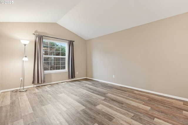 unfurnished room featuring lofted ceiling and light wood-type flooring