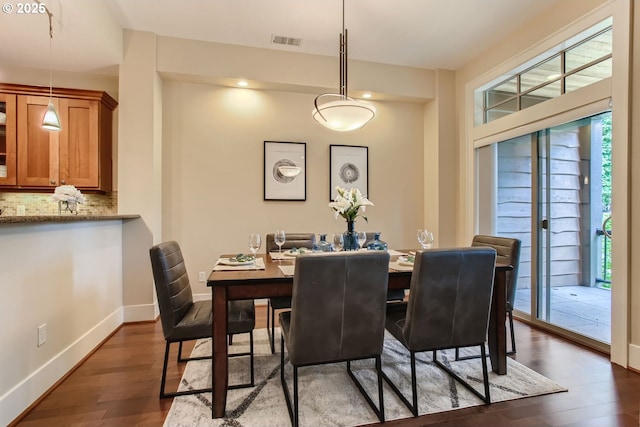 dining space featuring visible vents, baseboards, and dark wood-style floors