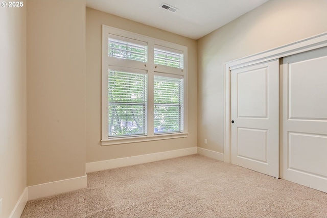 unfurnished bedroom featuring a closet, visible vents, carpet flooring, and baseboards