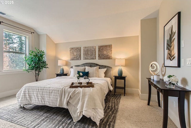 carpeted bedroom with baseboards, lofted ceiling, and visible vents