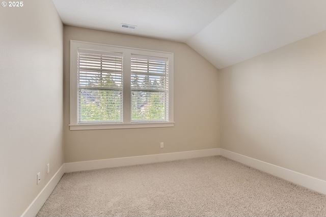 additional living space featuring baseboards, lofted ceiling, carpet, and visible vents