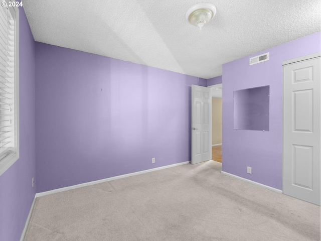 unfurnished bedroom featuring carpet flooring, visible vents, and baseboards