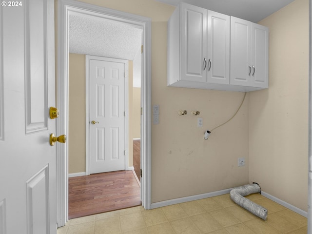 washroom featuring washer hookup, cabinet space, and baseboards