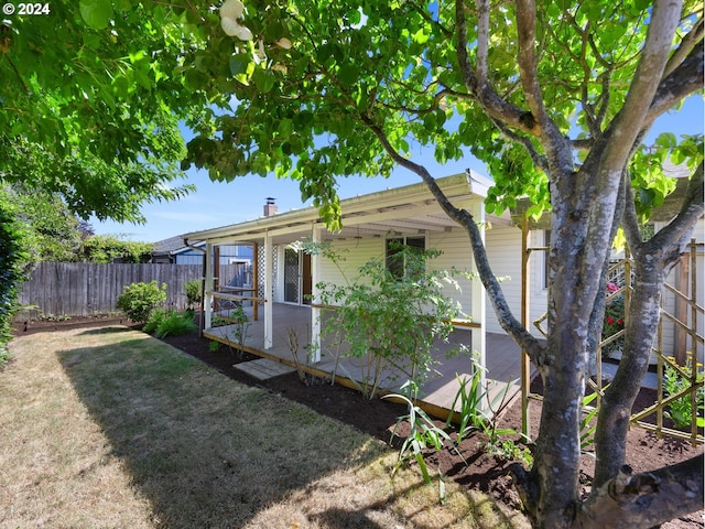 exterior space featuring a chimney, fence, and a yard