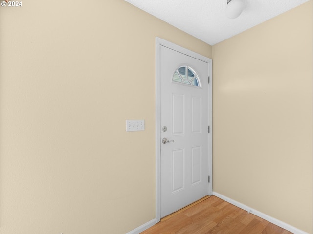 entryway with light wood finished floors and baseboards