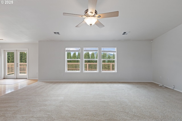 spare room featuring french doors, visible vents, and a healthy amount of sunlight