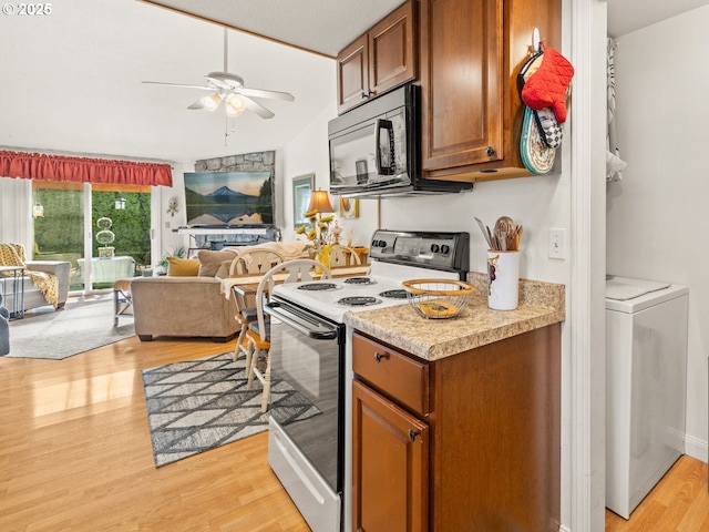 kitchen with light wood-type flooring, electric range, black microwave, washer / dryer, and ceiling fan