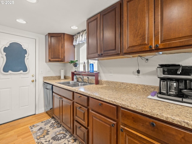 kitchen with dishwashing machine, recessed lighting, light wood finished floors, and a sink