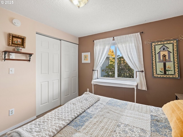 bedroom featuring a closet, baseboards, and a textured ceiling