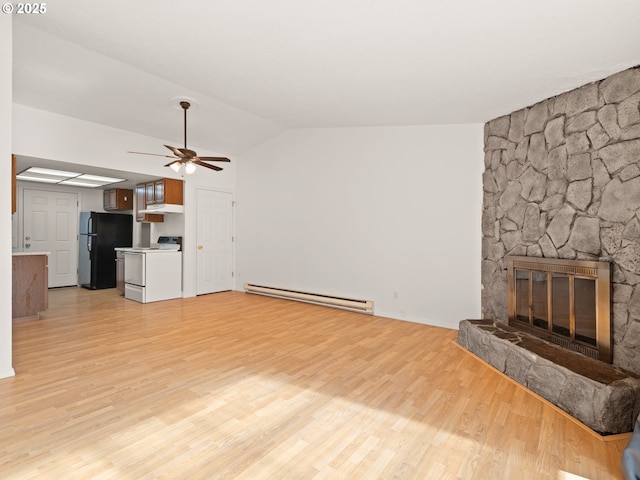 unfurnished living room with light wood-style floors, a stone fireplace, baseboard heating, ceiling fan, and vaulted ceiling