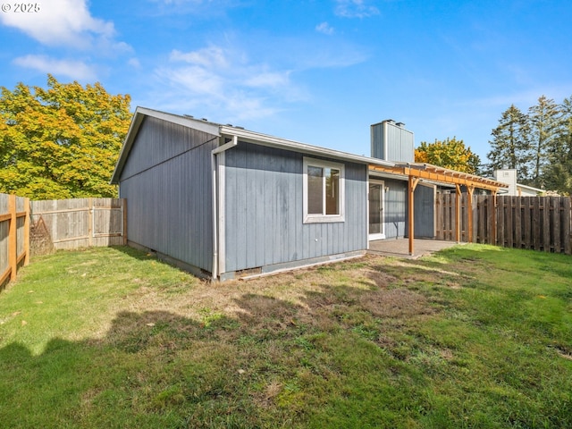 back of house with a yard, a patio area, a fenced backyard, and a pergola