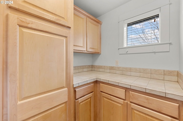 kitchen featuring light brown cabinets and tile counters