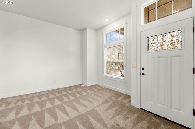 foyer with light carpet, baseboards, and recessed lighting