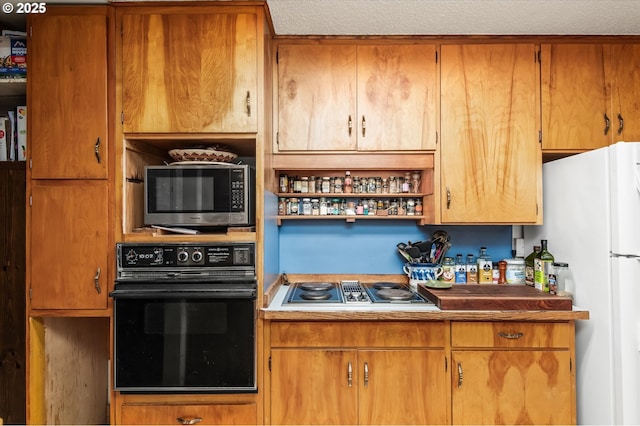 kitchen with stovetop with downdraft, black oven, freestanding refrigerator, open shelves, and brown cabinetry