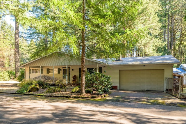 ranch-style house featuring a porch, driveway, and an attached garage