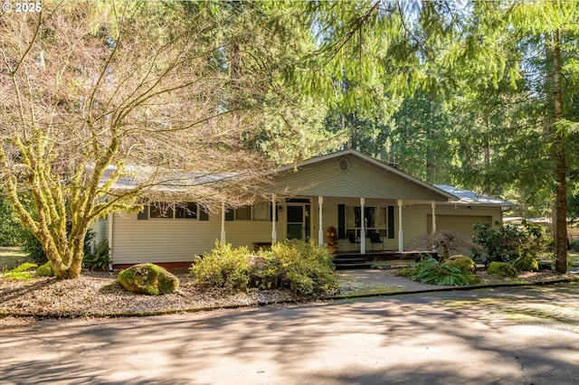 ranch-style home with driveway, a porch, and an attached garage