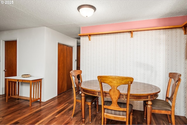 dining space featuring a textured ceiling and dark wood finished floors