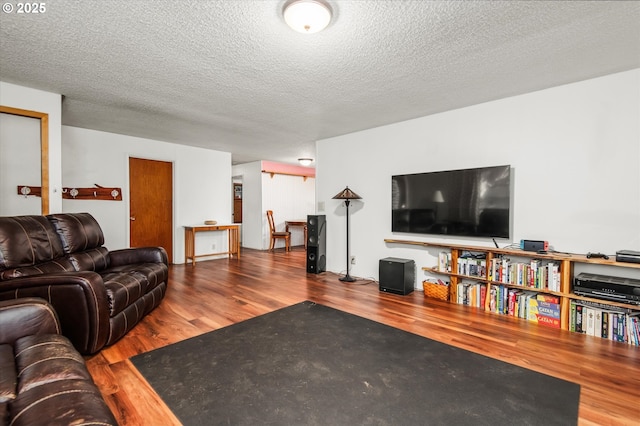 living room with a textured ceiling and wood finished floors