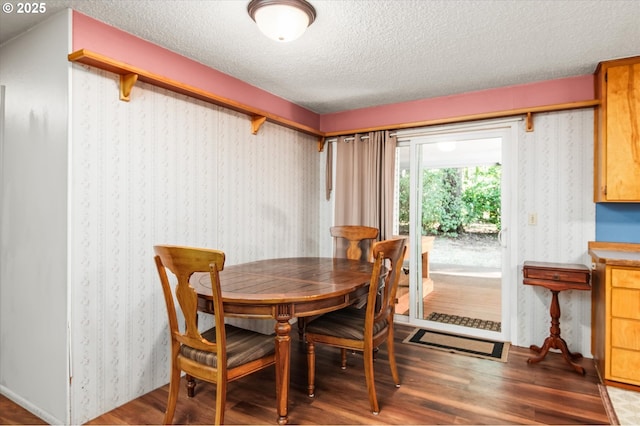 dining area featuring a textured ceiling and wood finished floors