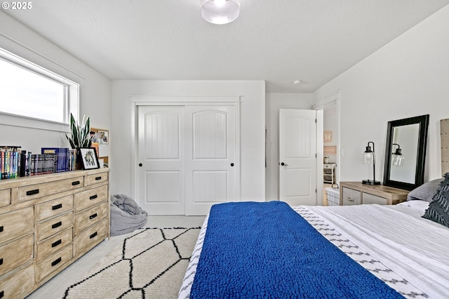 bedroom with a textured ceiling and a closet