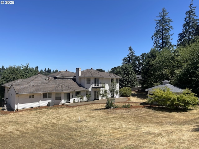 back of house featuring a yard and a balcony