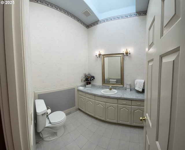 bathroom featuring vanity, tile patterned floors, and toilet