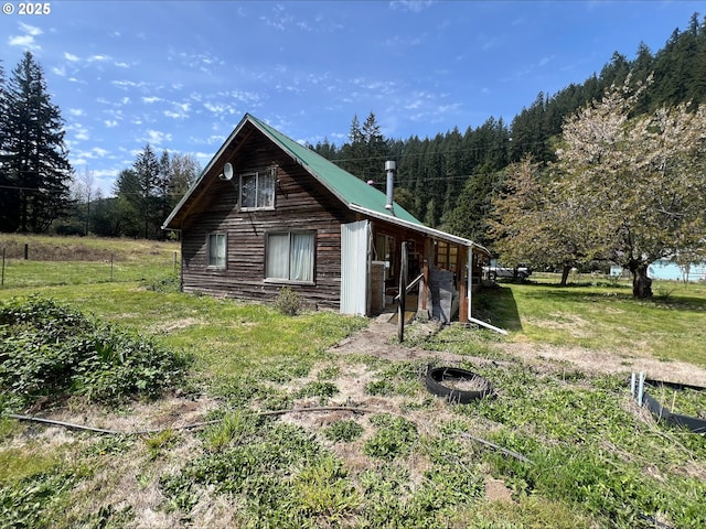 view of property exterior with a forest view