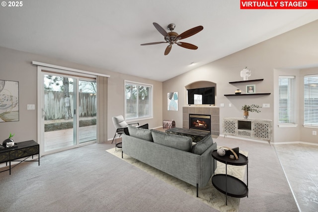 carpeted living room with lofted ceiling, a fireplace, and ceiling fan