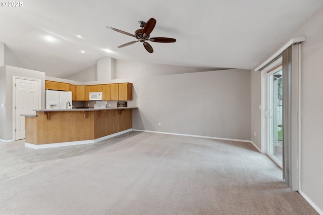 kitchen with white appliances, vaulted ceiling, light carpet, kitchen peninsula, and ceiling fan