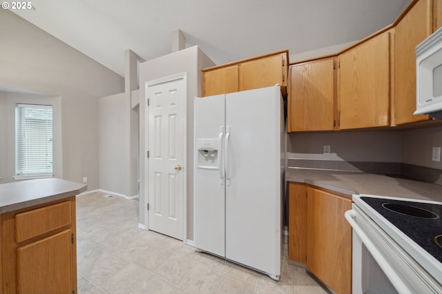 kitchen with white appliances, lofted ceiling, and light tile patterned floors