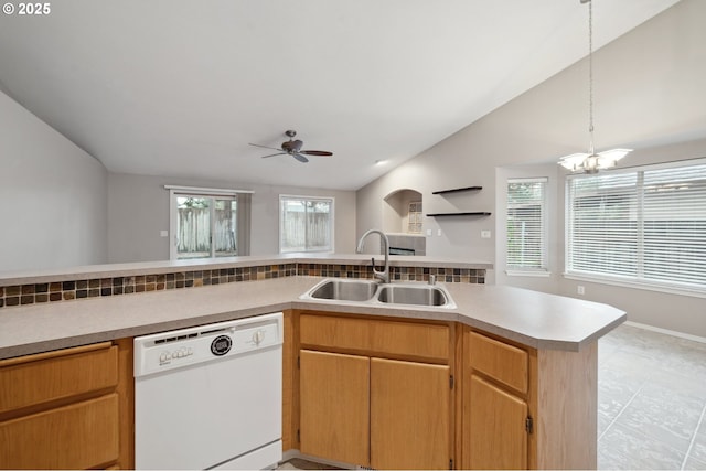 kitchen featuring vaulted ceiling, ceiling fan with notable chandelier, dishwasher, sink, and kitchen peninsula