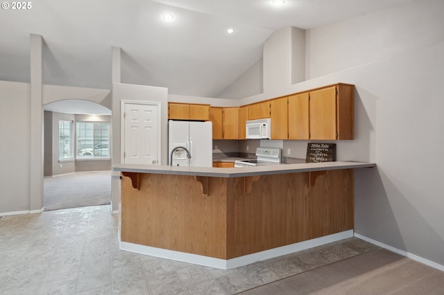 kitchen with high vaulted ceiling, white appliances, and kitchen peninsula