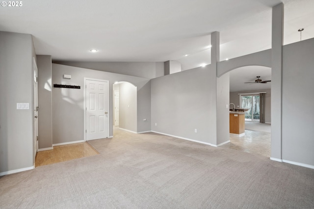 spare room with ceiling fan, light colored carpet, lofted ceiling, and sink