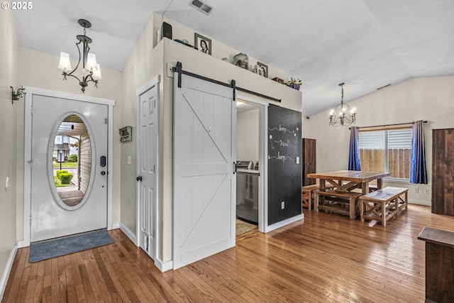 112 Stoneway Ln, Longview, WA 98632 - entrance foyer featuring a chandelier, a barn door, hardwood / wood-style flooring, vaulted ceiling, and baseboards