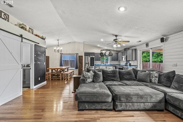 112 Stoneway Ln, Longview, WA 98632 - living area with a barn door, a textured ceiling, hardwood / wood-style flooring, a chandelier, and lofted ceiling