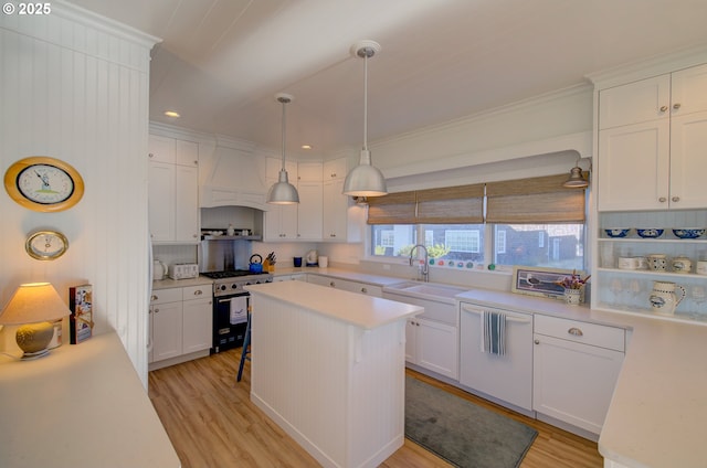 kitchen featuring sink, white cabinetry, decorative light fixtures, light hardwood / wood-style flooring, and high end stainless steel range oven