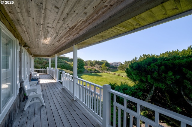 wooden deck featuring a lawn