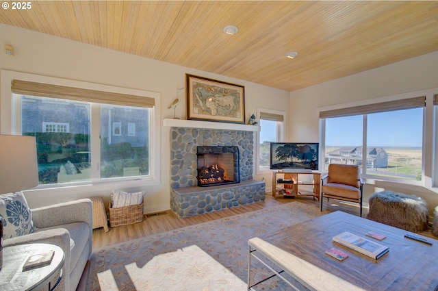 living room featuring wood ceiling, a fireplace, and light hardwood / wood-style floors