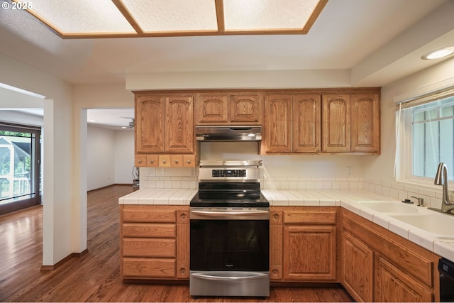 kitchen with electric range, under cabinet range hood, healthy amount of natural light, dark wood-style flooring, and recessed lighting