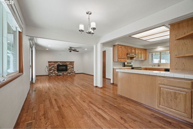kitchen featuring stainless steel electric stove, open shelves, a ceiling fan, a chandelier, and open floor plan