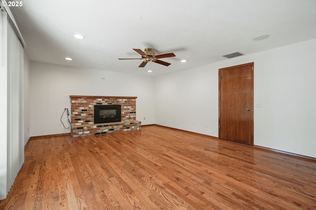 unfurnished living room featuring a ceiling fan, light wood-type flooring, recessed lighting, and a brick fireplace