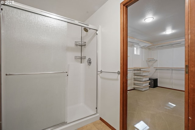 bathroom featuring a stall shower and baseboards