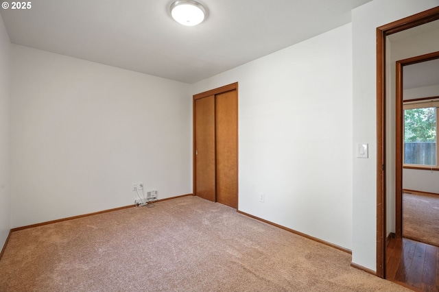 unfurnished bedroom featuring carpet, a closet, and baseboards