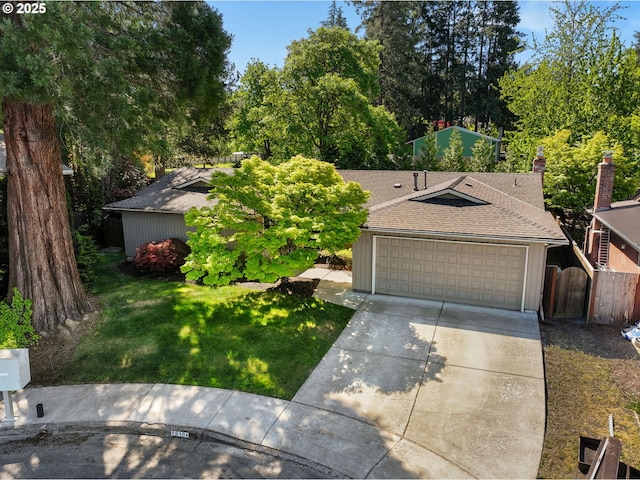 view of front of home featuring concrete driveway, roof with shingles, an attached garage, and view of wooded area