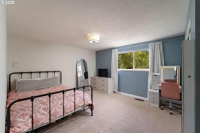 carpeted bedroom featuring a textured ceiling, visible vents, and baseboards