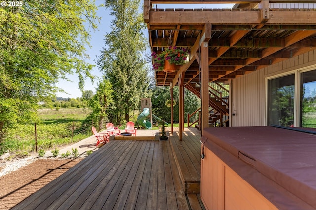 deck with a hot tub and stairway
