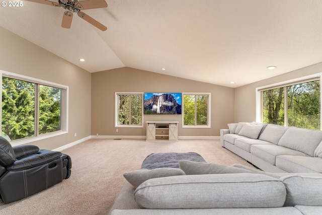living area with ceiling fan, light carpet, plenty of natural light, baseboards, and lofted ceiling